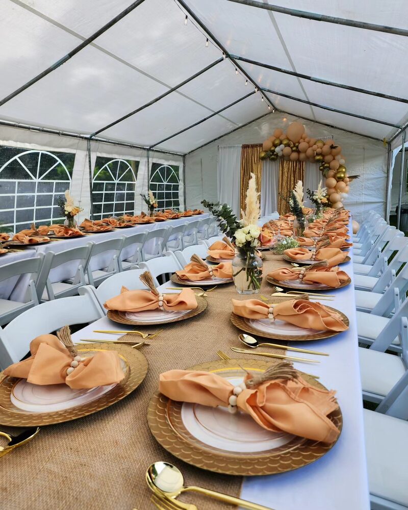 Boho orange and tan outdoor tent long table setting