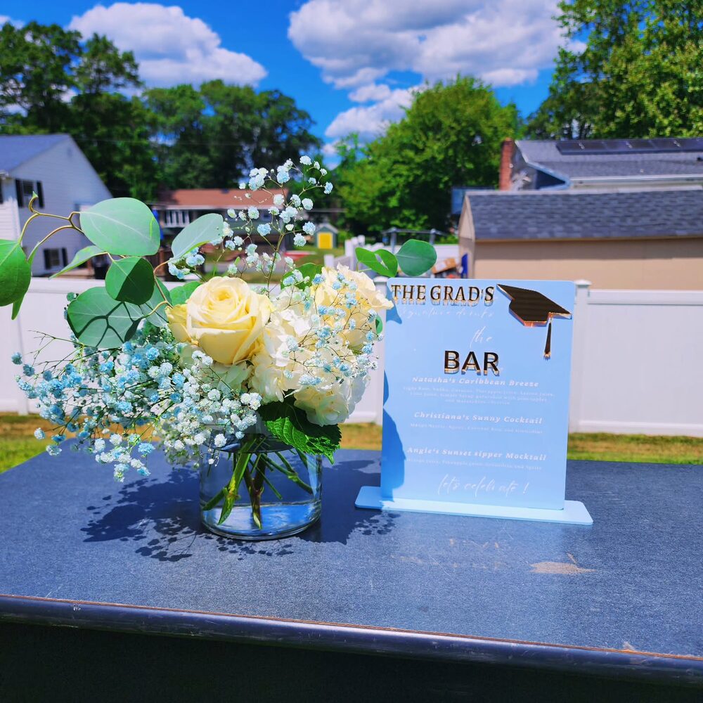 Graduation bar sign styled with white and blue florals