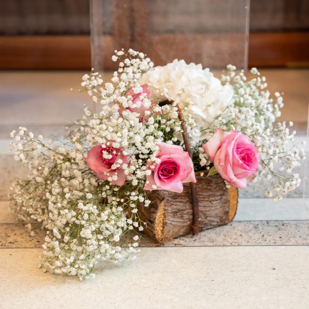 Rustic log basket arrangement with pink roses and baby's breath
