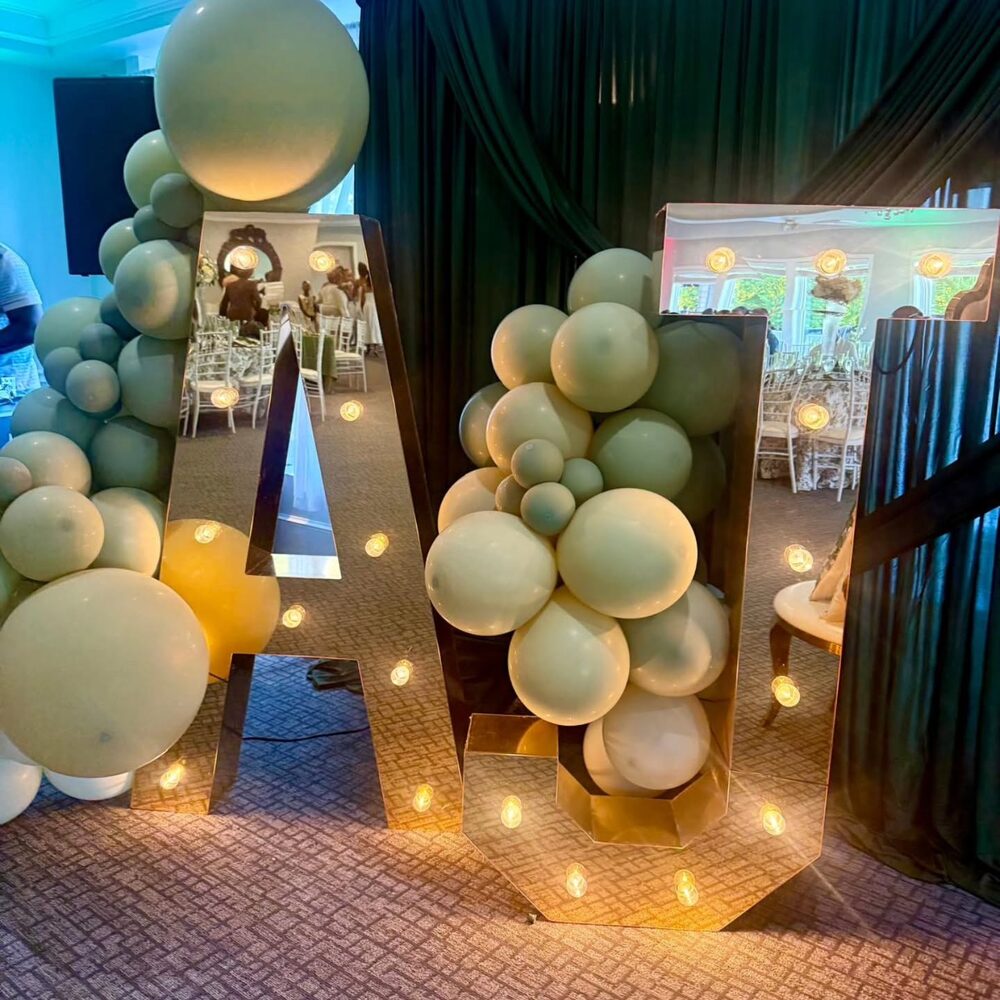 Mirror marquee letters with sage and gold balloon styling at an event